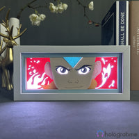 Boite lumineuse Aang Avatar allumée lumière rose-rouge, visage déterminé avec flèche bleue et flammes découpées