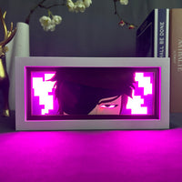 Boite lumineuse Aizen Bleach illuminée rose magenta, visage avec cache-oeil lumineux posée sur bureau manga