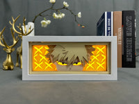 Boite lumineuse Bakugo My Hero Academia fond jaune doré avec croix explosives, regard féroce du héros rival