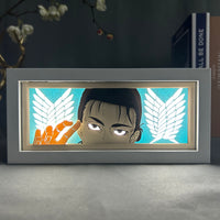 Boite lumineuse Eren Jäger posée sur un bureau, fond turquoise avec les ailes de liberté de L'Attaque des Titans