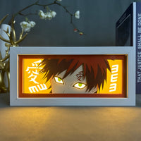 Boite lumineuse Gaara Naruto avec yeux verts lumineux et kanji Ai, éclairage chaud doré posée sur un bureau
