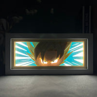 Boite lumineuse Goku Dragon Ball illuminée dans l'obscurité, rayons d'énergie turquoise et silhouette Super Saiyan lumineuse
