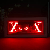 Boite lumineuse Gon en mode puissance, lettres X blanches lumineuses et regard intense illuminé en rouge intense