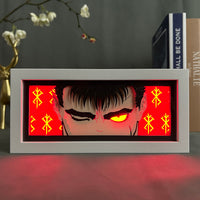Boite lumineuse Guts Berserk rétroéclairage rouge intense, yeux dorés lumineux et marques de berserker sur fond écarlate