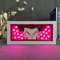Boite lumineuse Hisoka éclairée rose vif, yeux roses lumineux et symboles de cartes à jouer sur fond magenta brillant