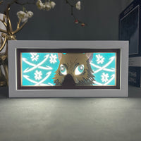 Boite lumineuse Inosuke allumée bleu turquoise, masque sanglier de Kimetsu no Yaiba avec motifs floraux découpés lumineux