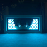 Boite lumineuse Isagi Yoichi posée sur un bureau, rétroéclairage bleu intense sur fond sombre avec motifs hexagonaux