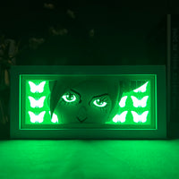 Boite lumineuse Jolyne JoJo allumée en vert foncé, silhouette et papillons lumineux visibles dans l'obscurité
