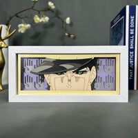 Boite lumineuse Jotaro Kujo JoJo posée sur bureau, fond violet avec mains découpées en papier, lumière naturelle