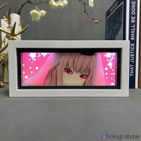 Boite lumineuse Mori Calliope Hololive lumière rose chaude, visage anime avec chapeau et motifs étoiles éclairés, posée
