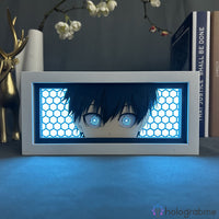 Boite lumineuse personnalisée éclairée en bleu LED, portrait en papier découpé d'un personnage anime, posée sur un bureau
