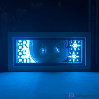 Boite lumineuse Rem Re:Zero éclairée en bleu avec motifs floraux et nom du personnage, posée sur un bureau