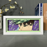 Boite lumineuse Rohan Kishibe JoJo posée sur bureau, fond violet avec idéogrammes japonais découpés, cadre blanc