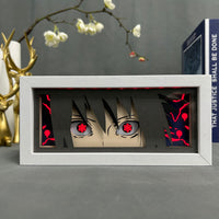 Boite lumineuse Sasuke Uchiha fond noir avec yeux sharingan rouge et motifs cursed seal, cadre blanc horizontal