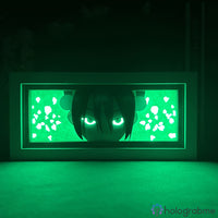 Boite lumineuse Toph Avatar mode sombre lumière verte intense, yeux lumineux et motifs rochers éclairés sur fond obscur
