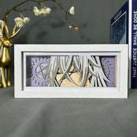 Boite lumineuse Undertaker Black Butler posée sur bureau, fond violet avec roues dentées et pentagramme découpés