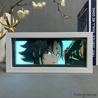 Boite lumineuse Xiao Genshin Impact en cadre blanc éclairée bleu-vert, gros plan yeux dorés et motifs décoratifs du