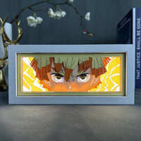 Boite lumineuse Zenitsu Demon Slayer illuminée jaune intense, éclairs découpés en papier multicouche encadrant le personnage