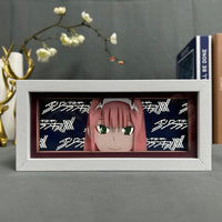 Boite lumineuse Zero Two cadre blanc, sourire expressif et cheveux roses avec pattern Darling in the FranXX fond bleu nuit
