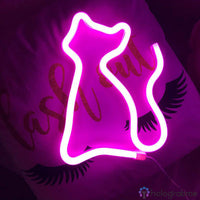 Néon LED chat silhouette rose fuchsia posé sur coussin avec motif cils, décoration chambre girly