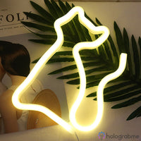 Néon LED chat silhouette blanc chaud posé sur feuilles tropicales, décoration chambre bohème estival