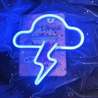 Néon LED nuage et éclair tout bleu électrique posé sur fond bleu satiné étoilé, décoration chambre enfant
