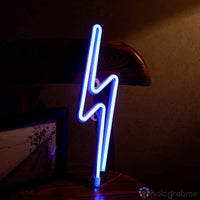 Néon LED éclair bleu électrique sur pied posé sur un meuble en bois, décoration bureau gaming ambiance sombre