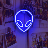 Néon LED alien bleu cobalt accroché sur mur recouvert de photos polaroid, décoration murale chambre ado minimaliste