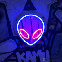 Néon LED alien tête extraterrestre bleu et rouge accroché sur mur graffiti urbain, décoration chambre gaming ou ado
