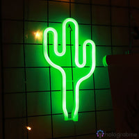 Néon LED cactus vert lumineux accroché sur un mur de carreaux blancs, décoration chambre bohème