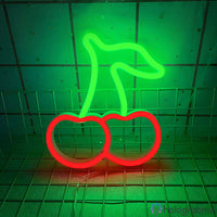 Néon LED cerise rouge et tige verte lumineux posé sur grille de présentation, décoration murale