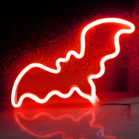 Néon LED chauve-souris rouge orange lumineux posé sur surface réfléchissante, décoration Halloween