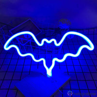 Néon LED chauve-souris bleu électrique aux ailes déployées posé sur une grille carrée
