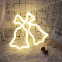 Néon LED cloches de Noël blanc chaud posé sur tissu et dentelle avec cerises, décoration festive