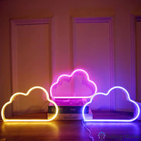 Trois néons LED nuage posés au sol couleurs jaune rose et violet, décoration salon ambiance cosy