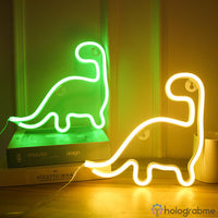 Deux néons LED dinosaure posés sur des livres, coloris vert et blanc chaud, décoration chambre ou salon