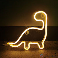 Néon LED dinosaure blanc chaud en silhouette de brontosaure posé au sol, ambiance lumineuse douce