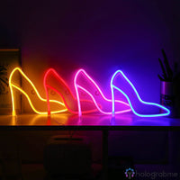 Quatre néons LED escarpin de couleurs différentes alignés sur un meuble, aperçu des teintes disponibles