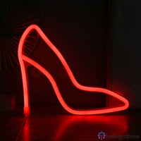 Néon LED escarpin talon haut rouge vif posé sur un parquet, décoration chambre ou dressing féminin