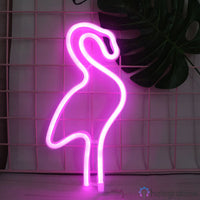 Néon LED flamant rose fuchsia posé sur un socle, silhouette sur grillage blanc, décoration chambre