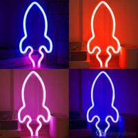 Quatre néons LED fusée en bleu rouge rose et violet présentés en quadrillage, décoration chambre ado thème espace