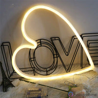 Néon LED grand cœur blanc chaud posé sur fourrure blanche avec lettres LOVE en métal, décoration