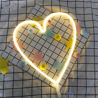 Néon LED grand cœur blanc chaud posé sur carrelage avec étoiles colorées, décoration chambre