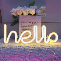 Néon LED hello blanc chaud en écriture cursive posé devant un bouquet de roses, décoration chambre romantique