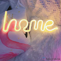 Néon LED home blanc chaud posé sur un coussin avec motif flamant rose, décoration chambre romantique