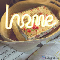 Néon LED home blanc chaud posé dans un panier tressé avec tissu fleuri, ambiance chambre déco bohème
