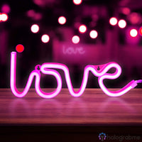Néon LED love rose fuchsia en script cursif posé sur une étagère en bois, ambiance bar romantique