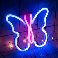 Néon LED papillon bleu et rose fuchsia bicolore accroché sur carrelage étoilé avec guirlande dorée, décoration chambre