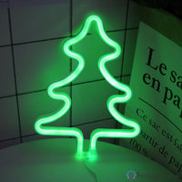 Néon LED sapin de Noël vert posé sur un bureau, lumière verte intense sur fond de carreaux blancs