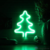 Néon LED sapin vert accroché au mur avec boules de Noël et végétation en décoration, ambiance fête lumineuse